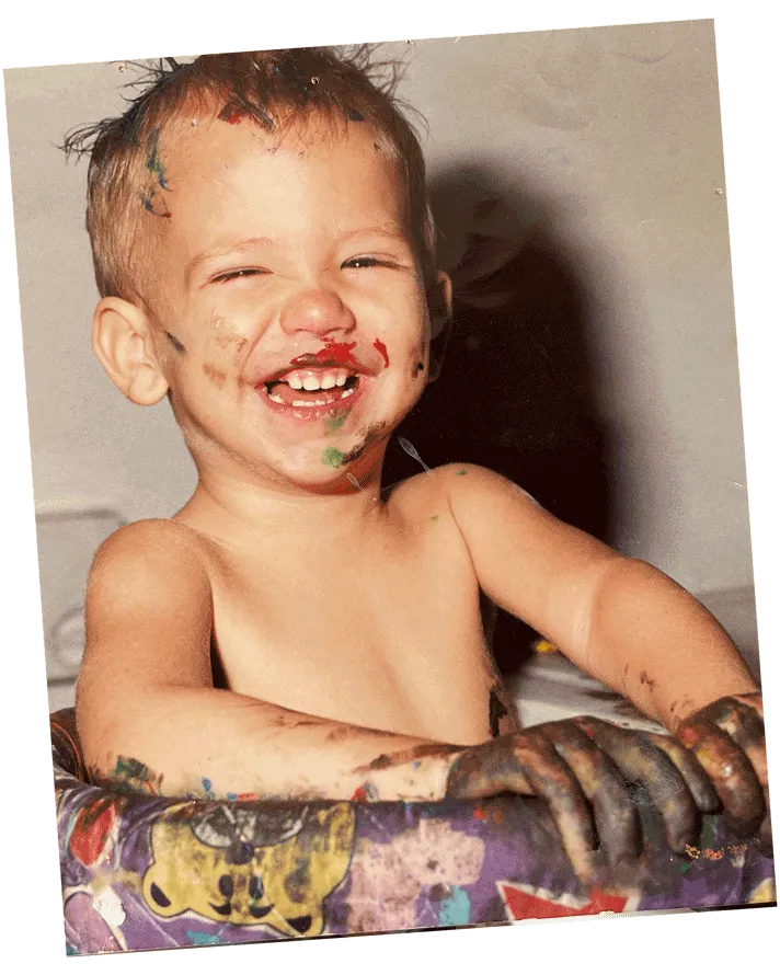 Héctor as a child, laughing, covered in paint